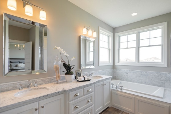 beautiful white bathroom with marble countertops and double-hung windows