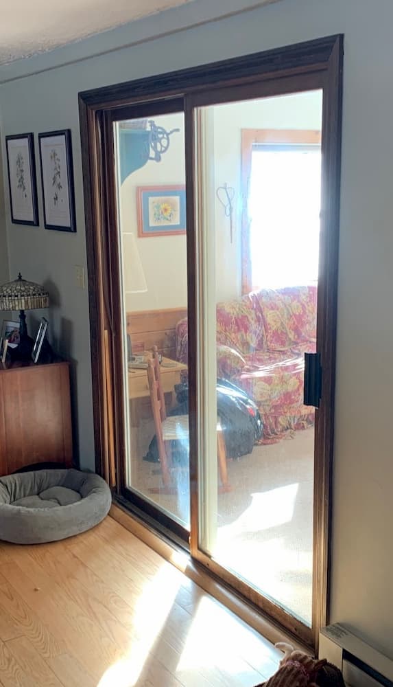 Wood sliding glass door opening onto a sun room