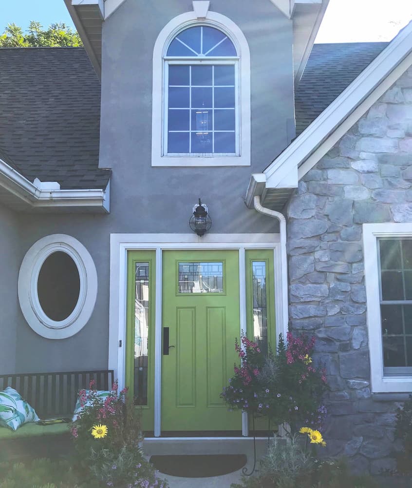 Front exterior view of gray home with new green fiberglass entry door with dual sidelights