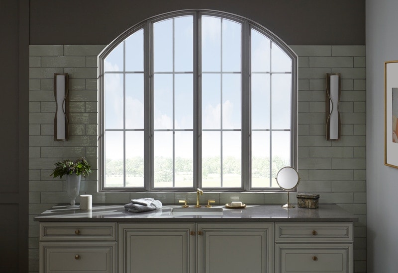 Arched window above bathroom sink