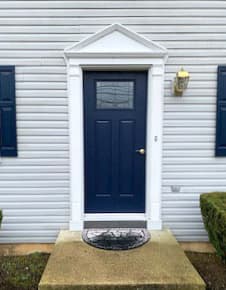 New blue fiberglass 2-panel 1/4 light entry door on home with white siding