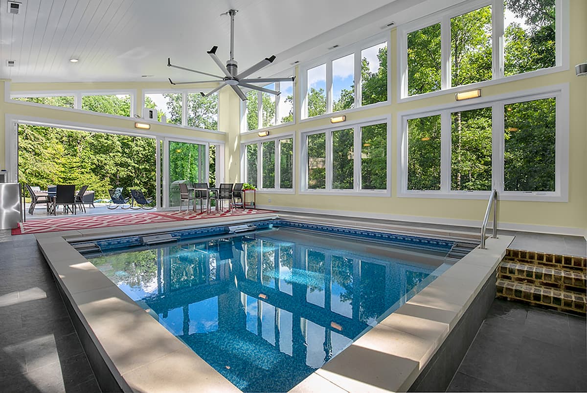 Interior view of pool house with wall of vinyl windows and sliding patio door