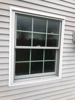 Exterior view of new double-hung window with traditional grille pattern 
