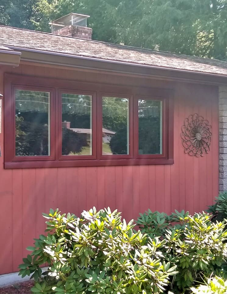 Exterior view of vinyl casement windows with a red finish on a red house