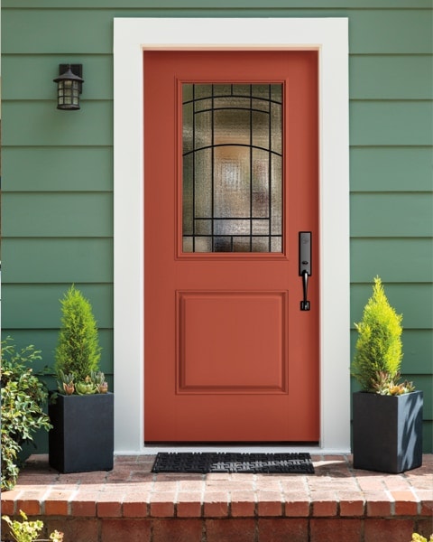 a color pop with complementary colored red entry door against green house siding