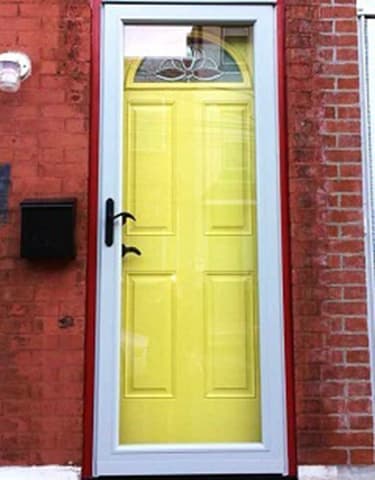 Yellow front door on brick exterior