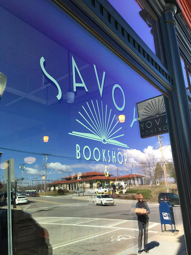Close-up of large wood storefront window on Savoy Bookstore