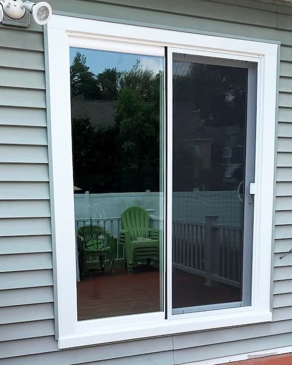 White sliding patio door on home with gray siding