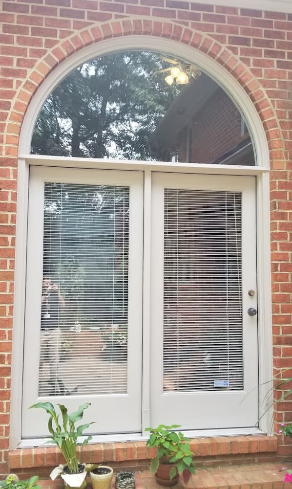Old double patio doors on red brick home