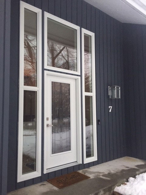 New fiberglass front entry door with transom windows and sidelights on Westfield home