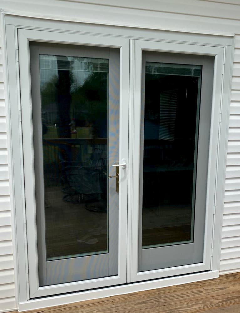 Exterior view of double hinged French patio doors with white storm doors