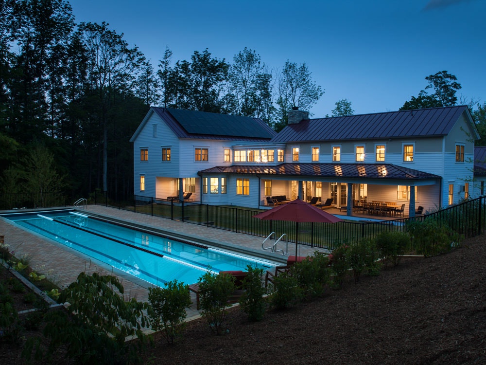 Exterior view of patio and pool at night at Berkshire residence in Massachusetts