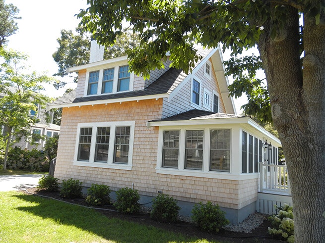 Side view of exterior of Cape Cod cottage with new wood windows