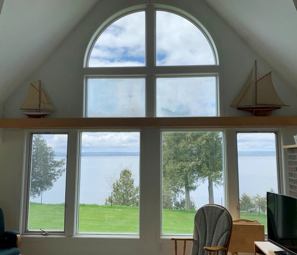 Interior view of multiple picture windows looking out onto Lake Champlain