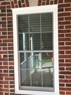 New white vinyl double-hung window on red brick home