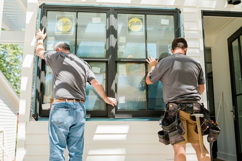Pella installation crew members set windows in an opening