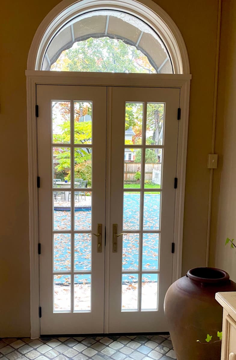 Interior view of new wood hinged French patio door with traditional grille pattern.