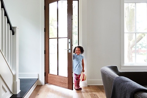 Small child enters a glass front door with multipoint locking system