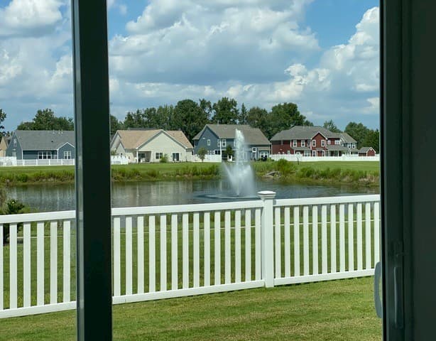 View through sliding glass door to nearby lake and fountain