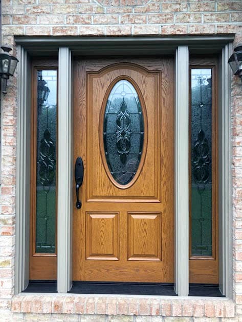 New wood-look fiberglass entry door with decorative glass sidelights