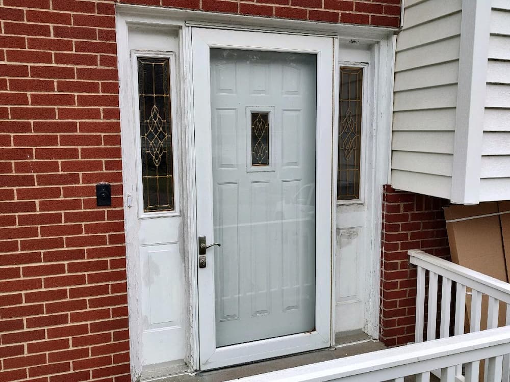 Old, scuffed white door with glass exterior door