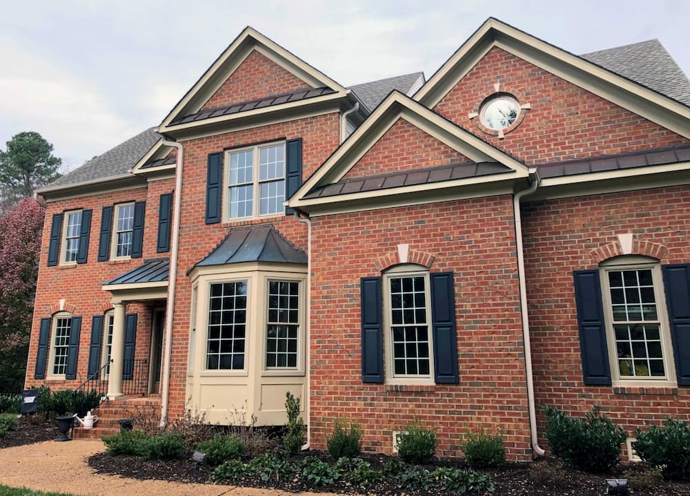 Front exterior view of red brick home with new wood double-hung windows