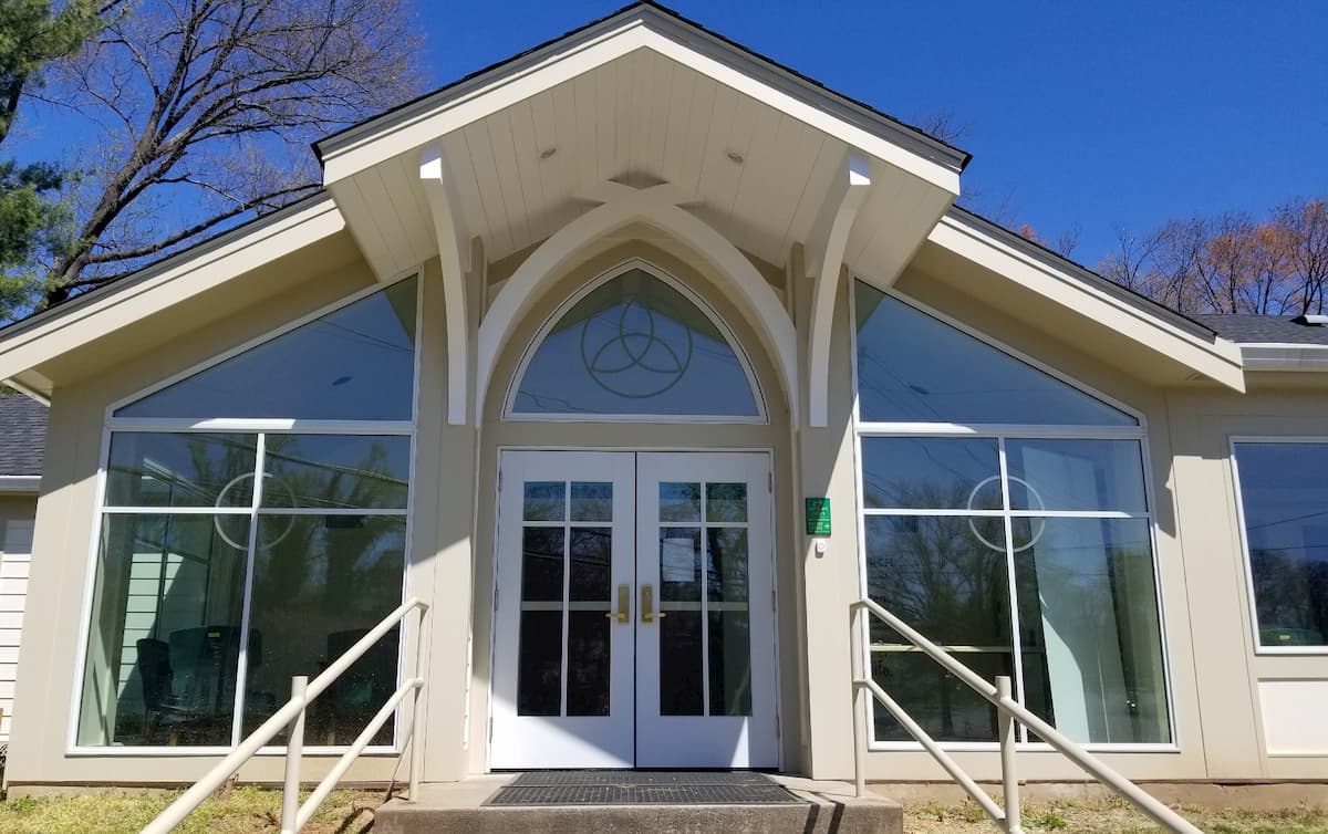 Front exterior view of a church with new double wood entry doors and custom windows