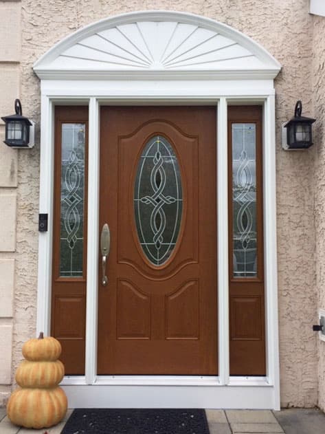 Wood-look fiberglass entry door system with decorative glass sidelights
