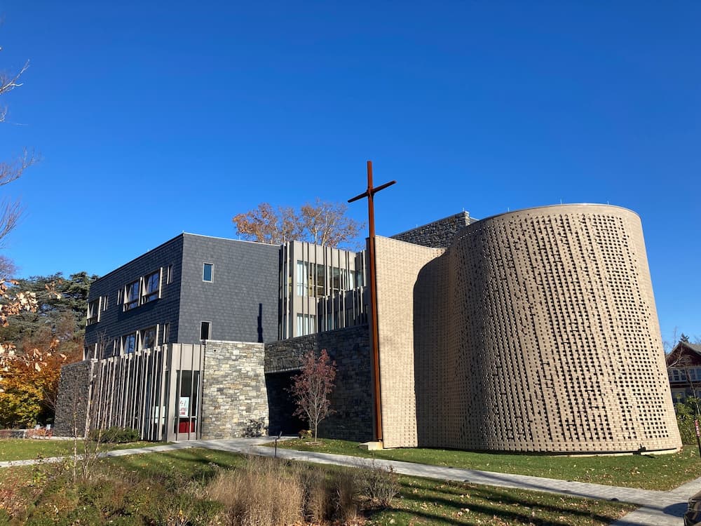 New university construction featuring gray windows and tall wooden cross