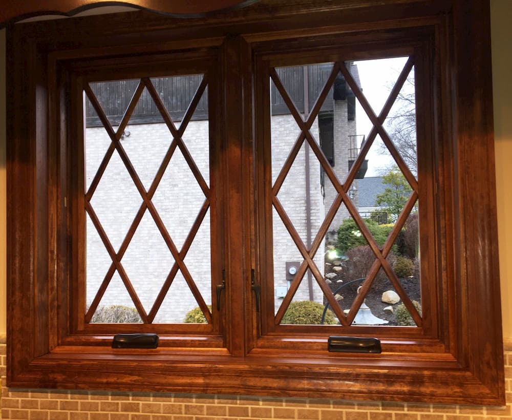 Interior view of two wood casement windows with diamond grille patterns