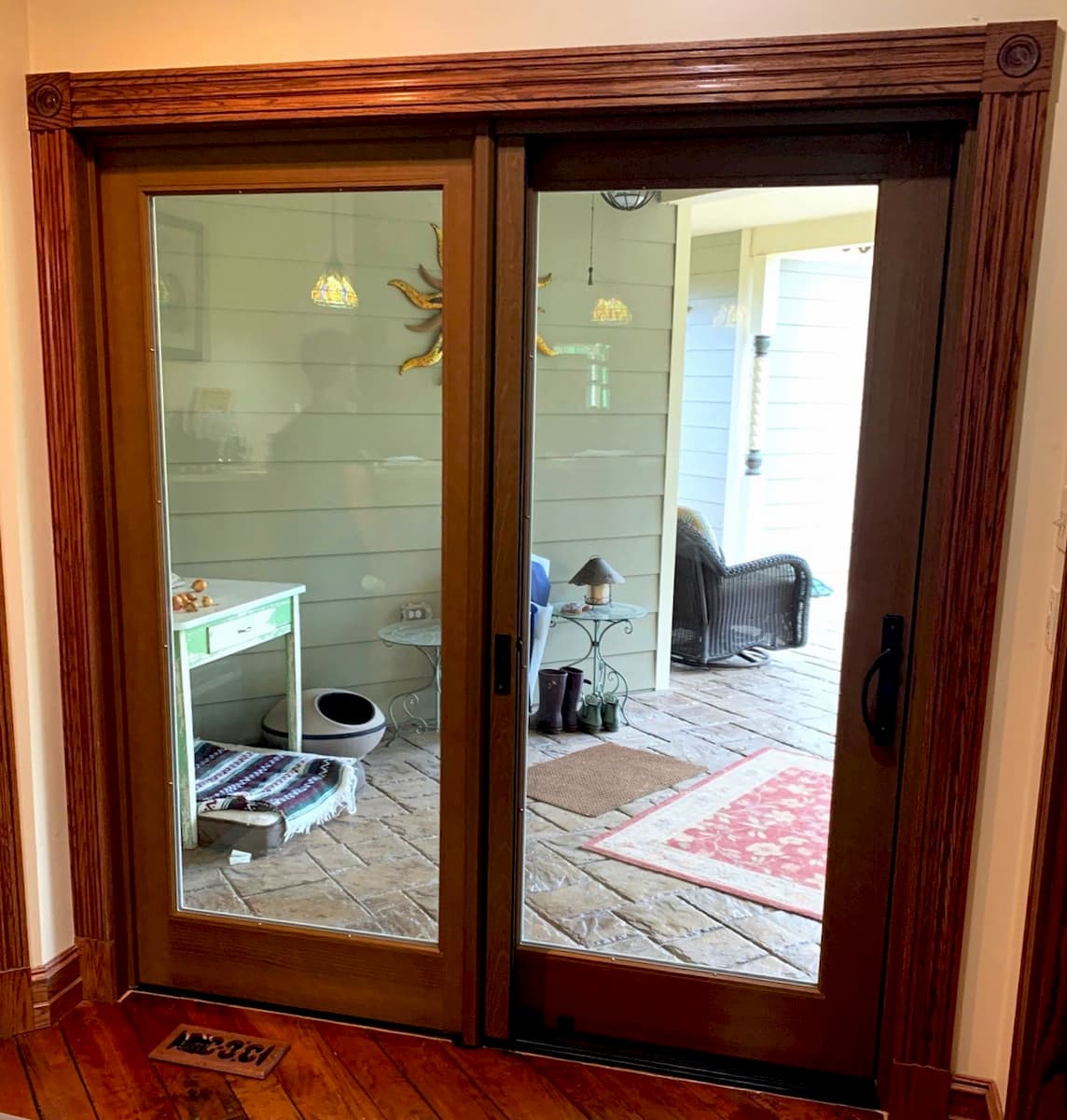 Interior view of wood sliding patio door with walnut stain and black hardware.