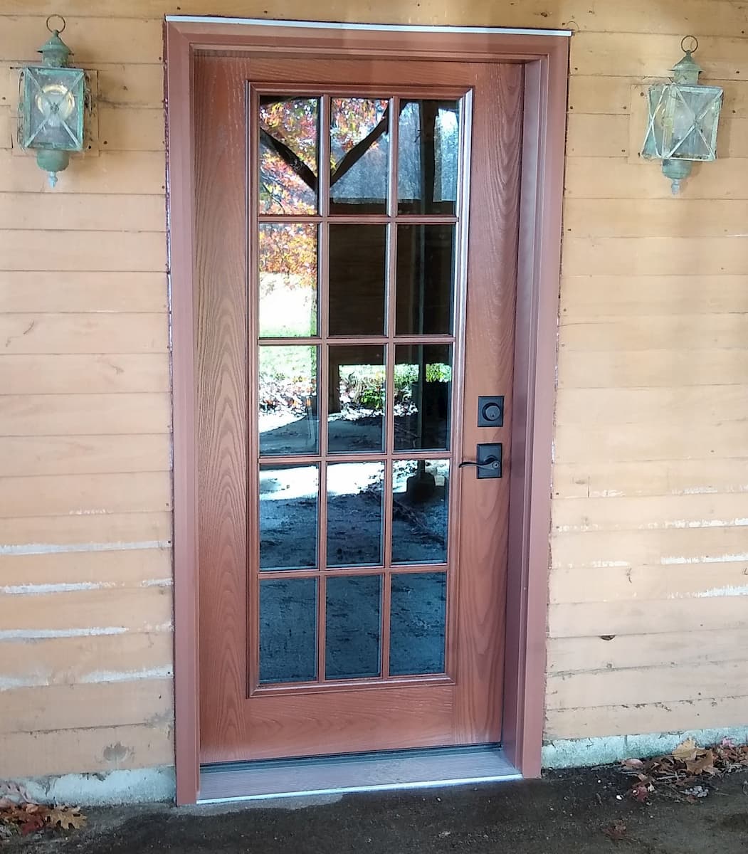 Exterior view of new fiberglass wood-look entry door.