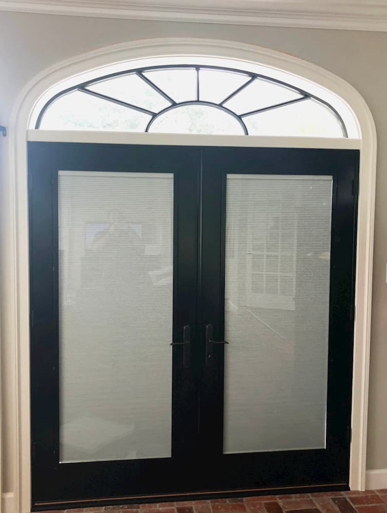 Interior view of black wood double French doors with transom window