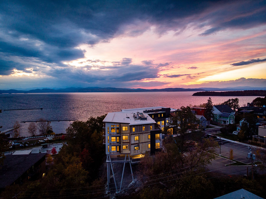 Front of One Lakeview Apartments in Burlington, Vermont, with new windows lit up at dusk