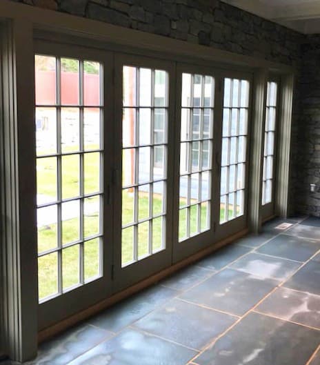 Interior view of wood bifold patio doors with traditional grille patterns
