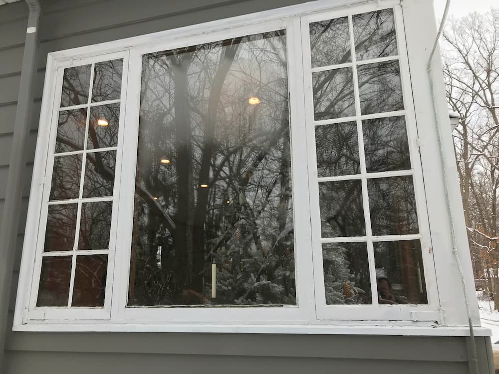 Exterior view of old wood casement and fixed windows on a gray home