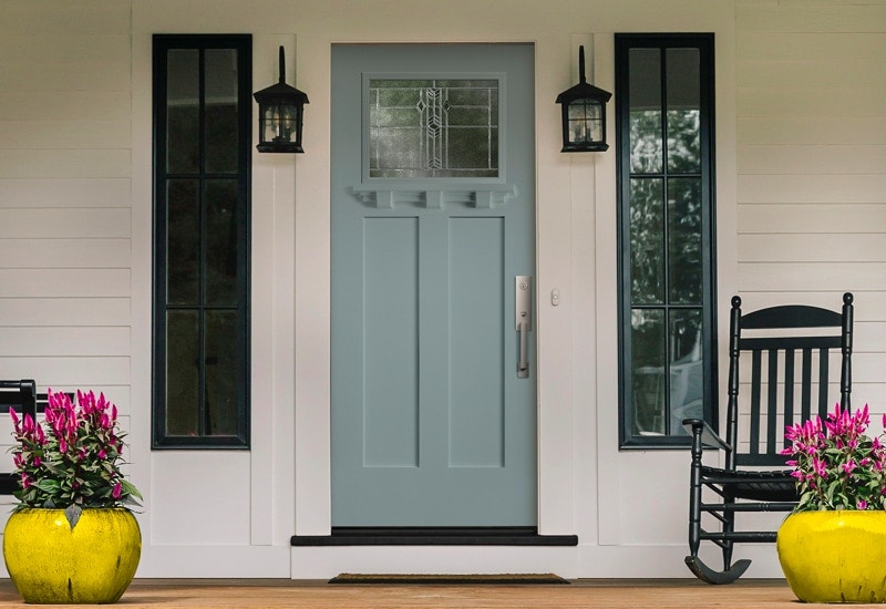 Bold, teal front door with sidelights