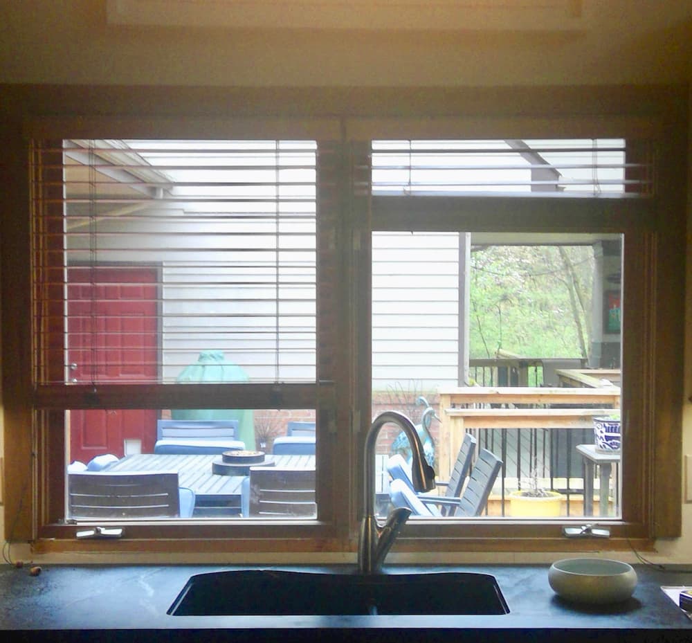 Interior view of old casement window with blinds over kitchen sink