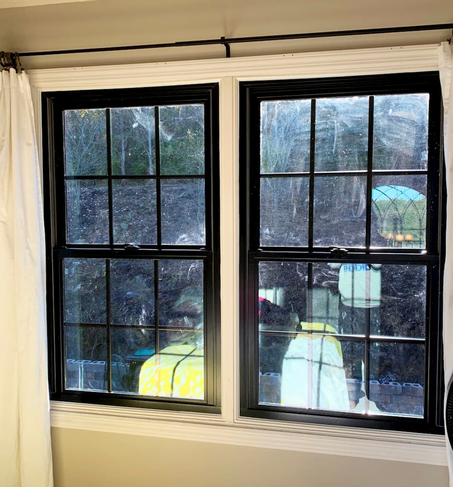 Interior view of black double-hung windows with traditional grille pattern