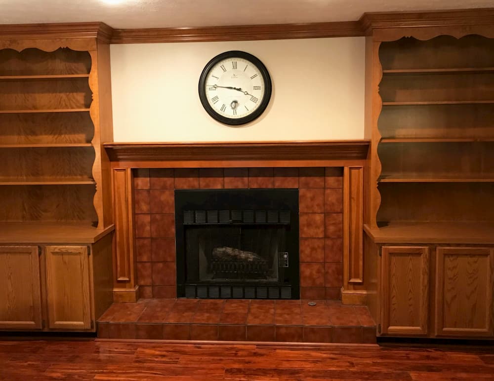 Old-fashioned living room with built-in wood bookcases flanking a fireplace