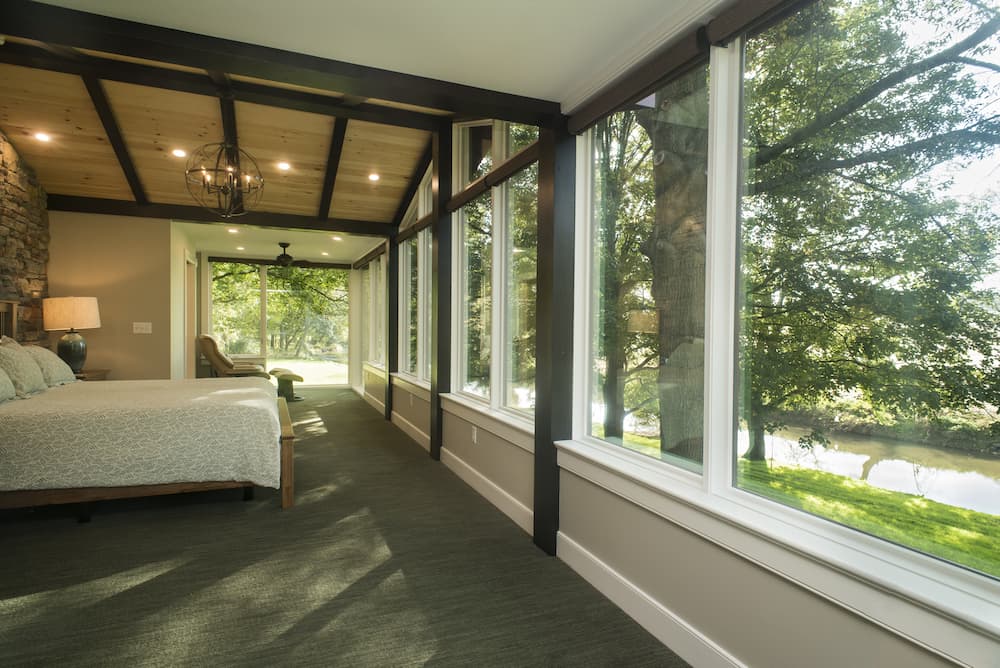 Wall of large, wood picture windows overlooking home's view
