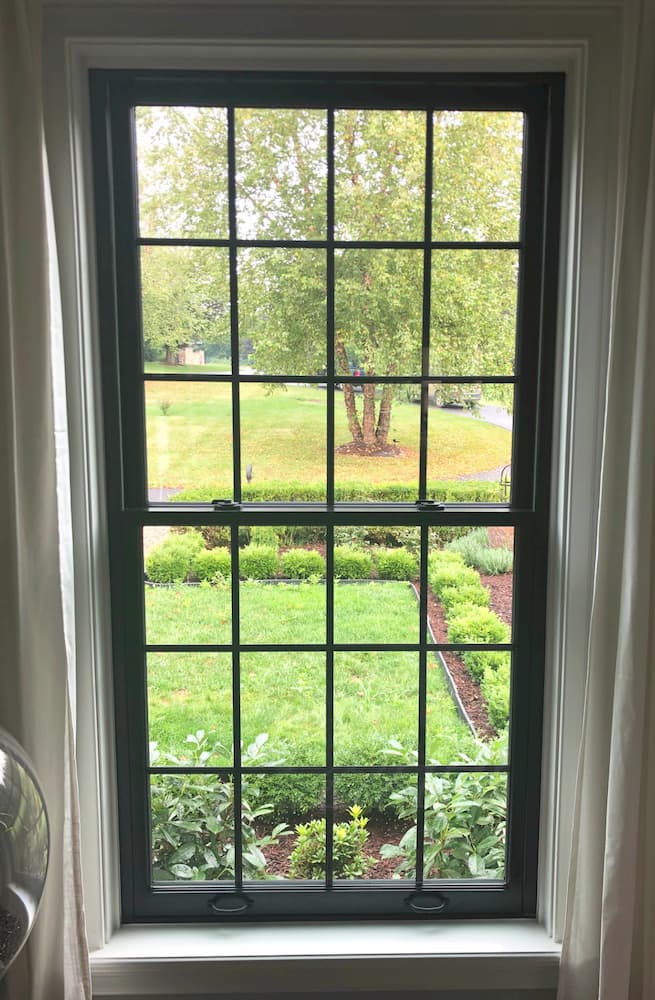 Interior view of black wood double-hung window with traditional grille pattern
