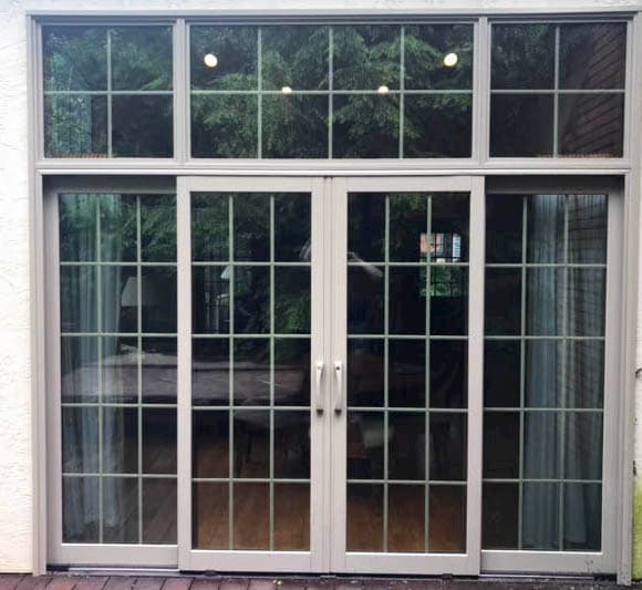 Exterior view of new wood double sliding glass doors with traditional grille pattern