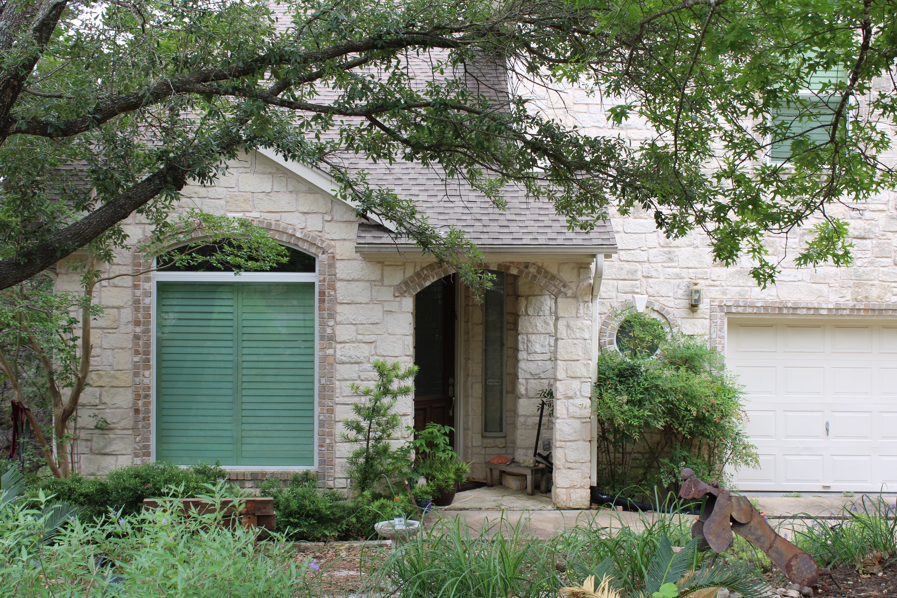 Stone front exterior and garage door of Austin home