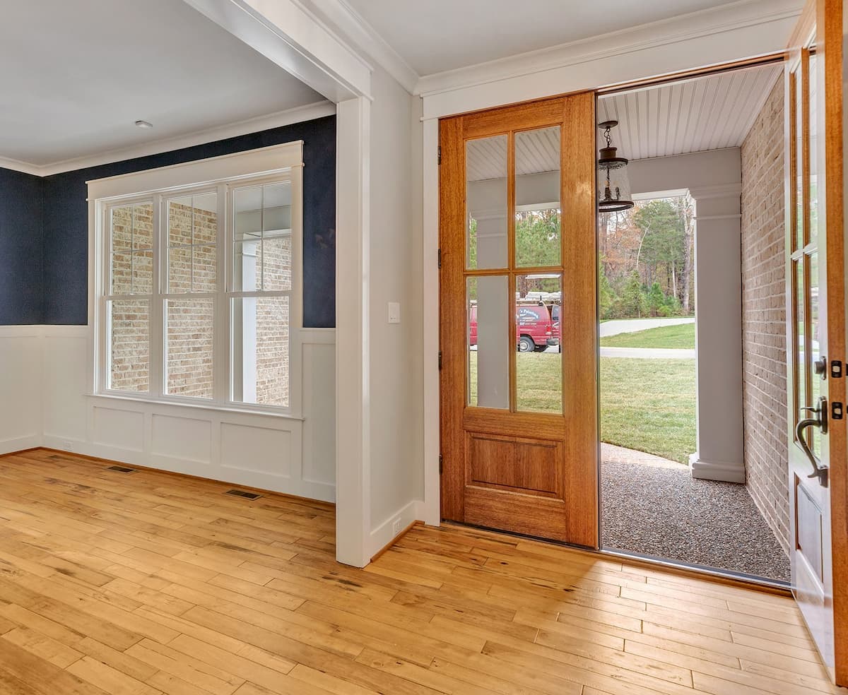 Interior view of white double-hung windows and wood entry doors