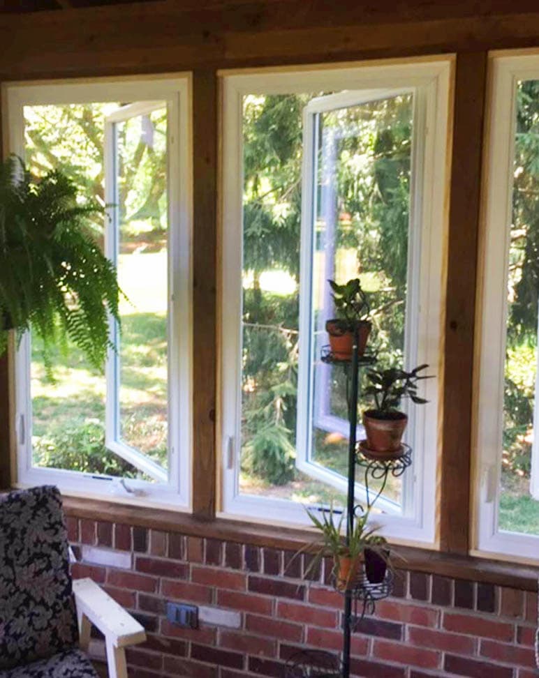 Interior view of new vinyl casement windows open onto a backyard