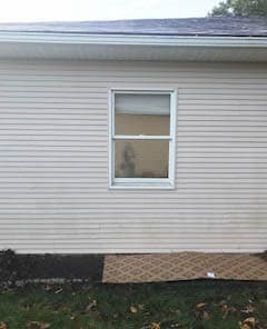 Exterior view of white double-hung window on side of home
