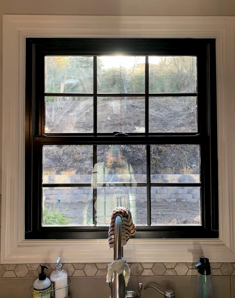 Interior view of black double-hung window with traditional grille pattern