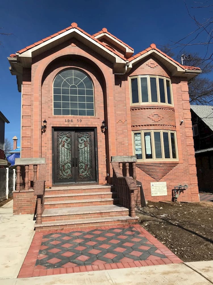 Red brick home with vinyl Palladian and bow windows.