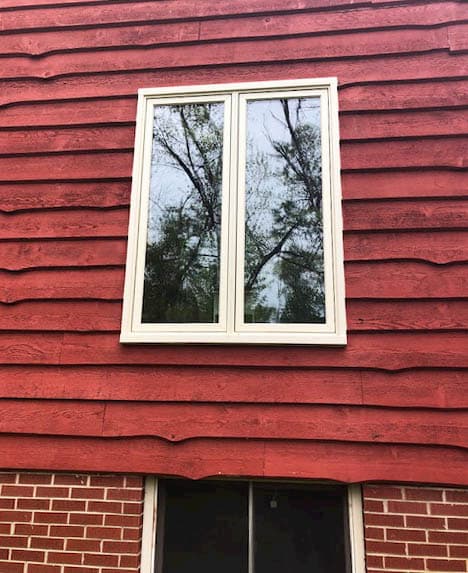 Exterior view of new wood casement windows on the side of a red Pepper Pike, Ohio, home.